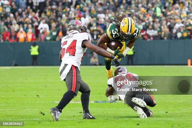 Aaron Jones of the Green Bay Packers is brought down by Christian Izien of the Tampa Bay Buccaneers during a game at Lambeau Field on December 17,...