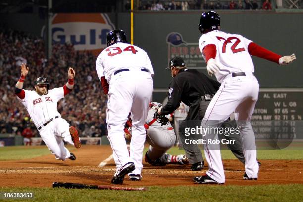 Jonny Gomes of the Boston Red Sox slides safely into home plate as Yadier Molina of the St. Louis Cardinals tries to make the play during Game Six of...