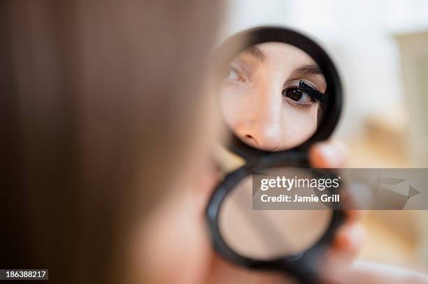 woman putting on mascara in compact mirror - powder compact 個照片及圖片檔
