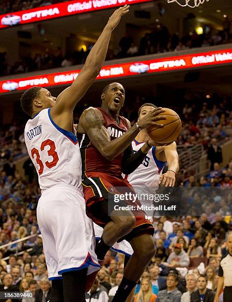 Guard Mario Chalmers of the Miami Heat drives to the basket with center Daniel Orton of the Philadelphia 76ers on October 30, 2013 at the Wells Fargo...