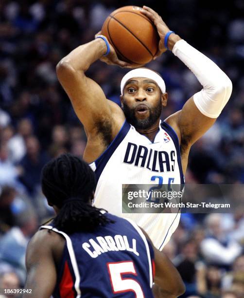 The Dallas Mavericks' Vince Carter looks to pass over the Atlanta Hawks' DeMarre Carroll at the American Airlines Center in Dallas, Texas, on...