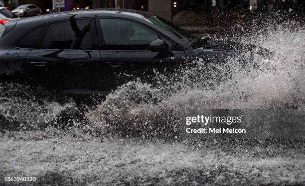 Motorist creates a big splash while driving thru a partially flooded Riverside Dr. In North Hollywood. The first of two storm systems is bringing...