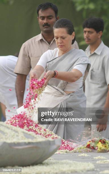 Congress President Sonia Gandhi is flanked by bodyguards as she prays at the cremation site and memorial to her husband and slain former premier...