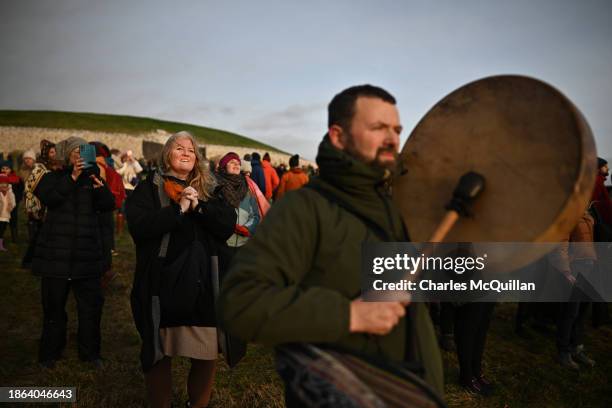 Gathering of people celebrate by singing and dancing as the sun rises during the Winter Solstice at Newgrange on December 21, 2023 in Newgrange,...