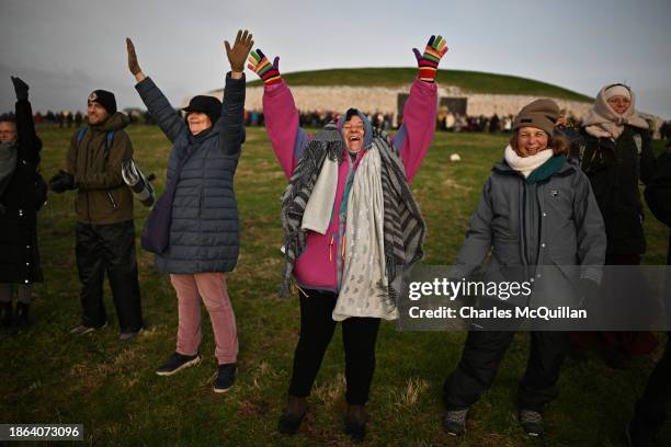 Gathering of people celebrate by singing and dancing as the sun rises during the Winter Solstice at Newgrange on December 21, 2023 in Newgrange,...