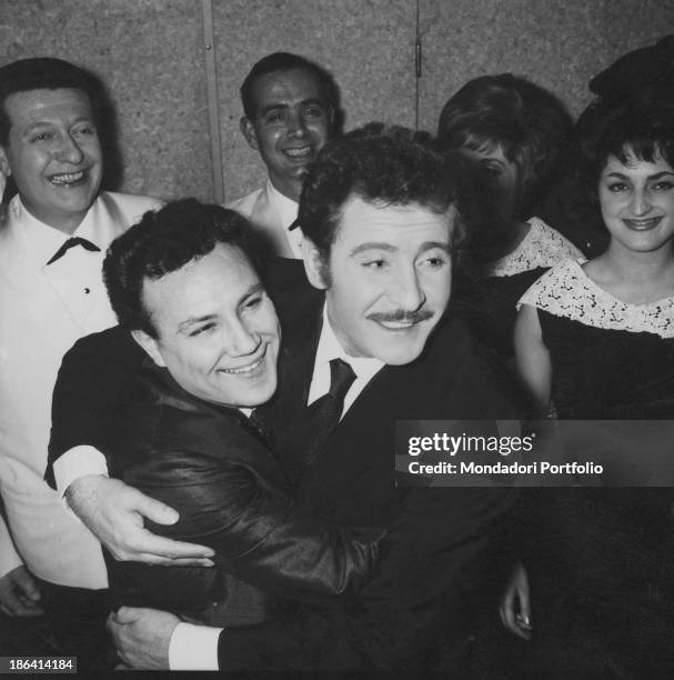 Italian singer-songwriter and actor Domenico Modugno hugging Italian singer and actor Claudio Villa during the 12th Sanremo Music Festival. They both...