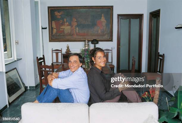 Italian singer-songwriter and writer Roberto Vecchioni posing with his wife, Italian journalist Daria Colombo, on the sofa of their new flat. Milan,...