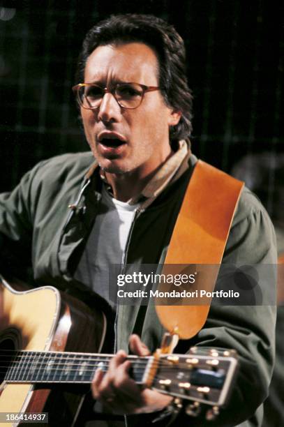 Italian singer-songwriter, stand-up comedian and actor Enzo Jannacci singing and playing guitar. 1980.