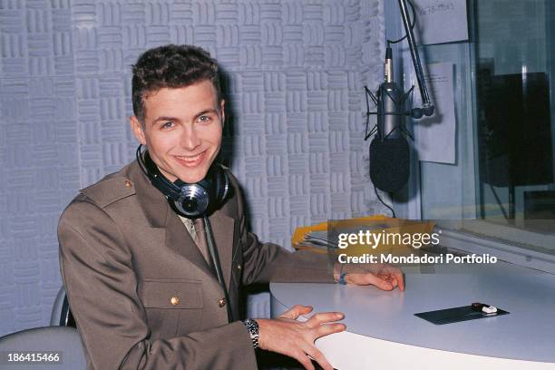 Italian singer-songwriter and dj Jovanotti wearing a uniform smiling in the recording studios of the radio station Radio Deejay. Milan, 1988.