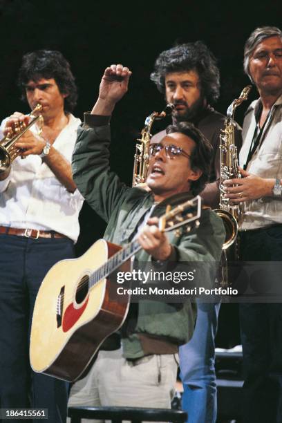 Italian singer-songwriter, stand-up comedian and actor Enzo Jannacci singing and playing guitar. 1980.