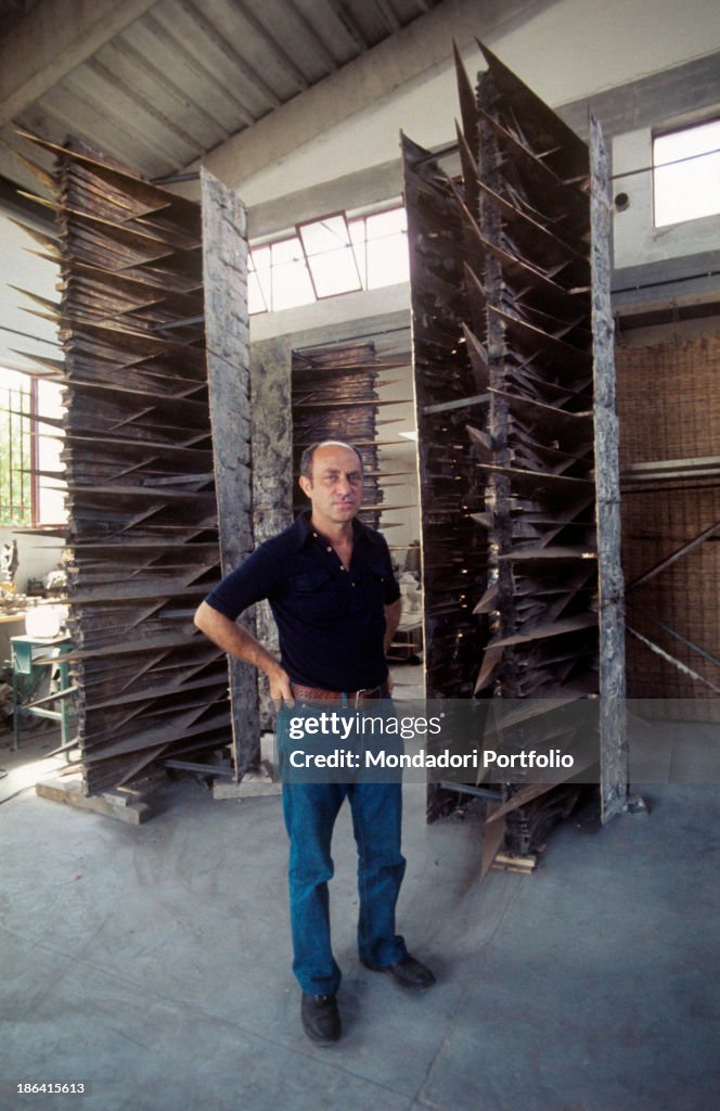 Arnaldo Pomodoro poses next to one of his artwork