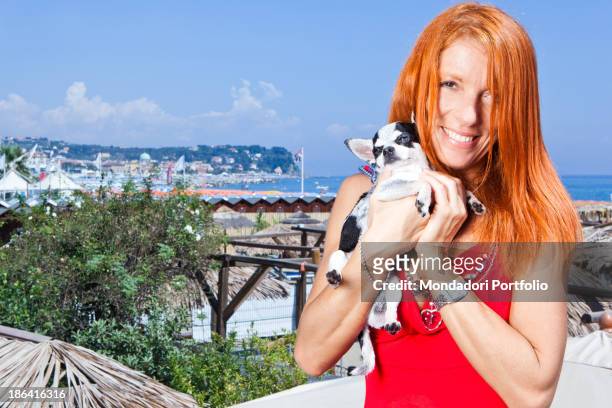 Italian politician and animalist Michela Vittoria Brambilla smiling with a Chihuahua dog in the hands at the lido Bau Bau Village. Albisola Marina,...