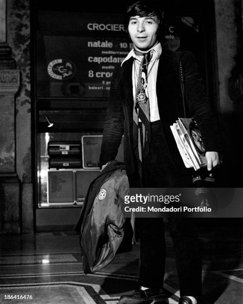 The drummer of the Italian music band Equipe 84, Alfio Cantarella, is ready to leave; in his hands a coat and some books. Italy, 1968.