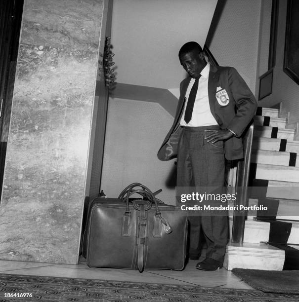 Brazilian football player Djalma Santos looking at a suitcase in Milan after the FIFA World Cup. Milan, June 1958.