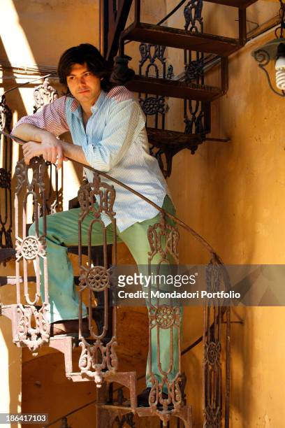 Vittorio Sgarbi's son Carlo Sgarbi Brenner leaning on a winding staircase of Villa Banfi. Vimercate, 2000s.