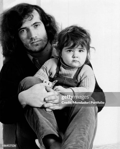 Thoughtful Franco Ceccarelli with his daughter Sandrina, aged 16 months, in his arms; Ceccarelli is the guitarist of the Italian music band from...