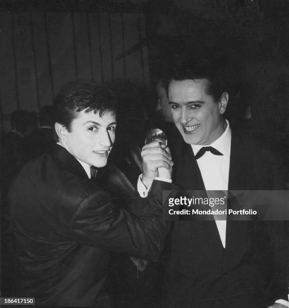 Italian singers Emilio Pericoli and Tony Renis shaking hands during the 13th Sanremo Music Festival. They both will win the Festival with the song...