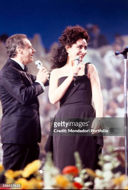 Italian singer and TV presenter Johnny Dorelli welcoming on stage Italian singer Mia Martini singing the song La nevicata del '56 at the 40th Sanremo...