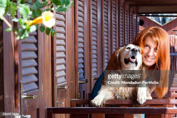 Italian politician and animalist Michela Vittoria Brambilla hugging a Golden Retriever dog in front of the bathing-huts at the lido Bau Bau Village....