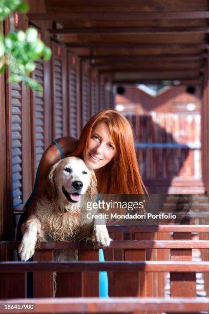 Italian politician and animalist Michela Vittoria Brambilla hugging a Golden Retriever dog in front of the bathing-huts at the lido Bau Bau Village....