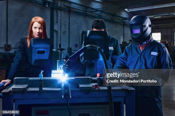 Two workers testing a welding beside Italian entrepreneur and politician Michela Vittoria Brambilla at the Trafilerie Brambilla factory....