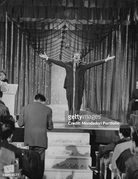 Italian singer-songwriter and actor Domenico Modugno performing the song Libero with his arms wide-opened on the stage of the 10th Sanremo Music...