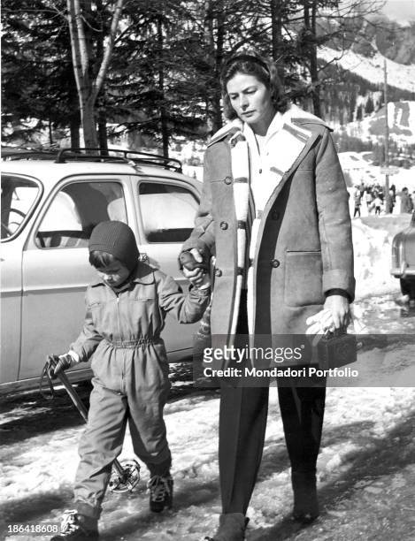 Swedish actress Ingrid Bergman walking hand in hand with her son Robertino. Sankt Moritz, 1950s.