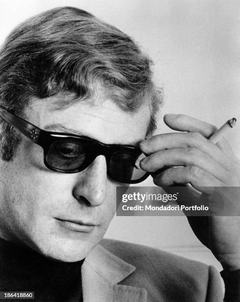 Close-up of the British actor Michael Caine, appreciated interpreter for thrillers and spy movies, portrayed with a cigarette in hand and the black...