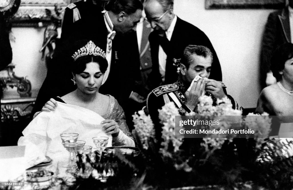 Farah Pahlavi and Mohammad Reza Pahlavi sitting at the table