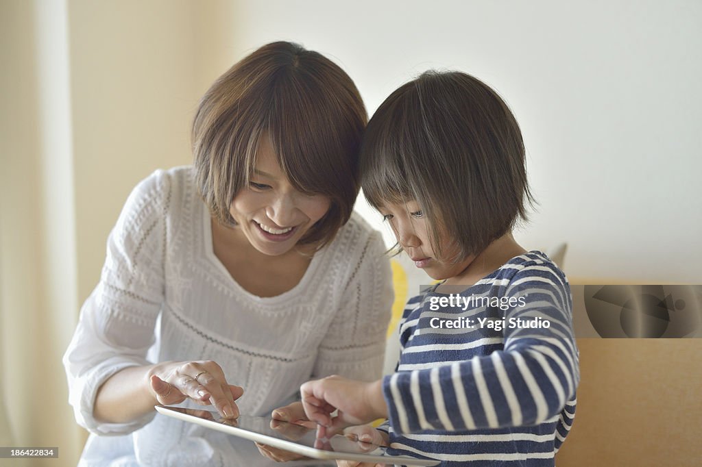 Girl using a digital tablet with Mother