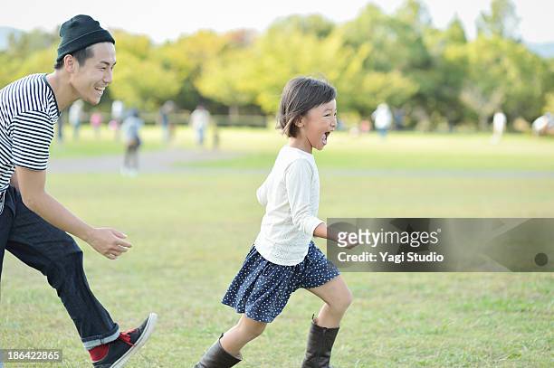 father and daughter playing in the park - 家族　日本人　走る ストックフォトと画像