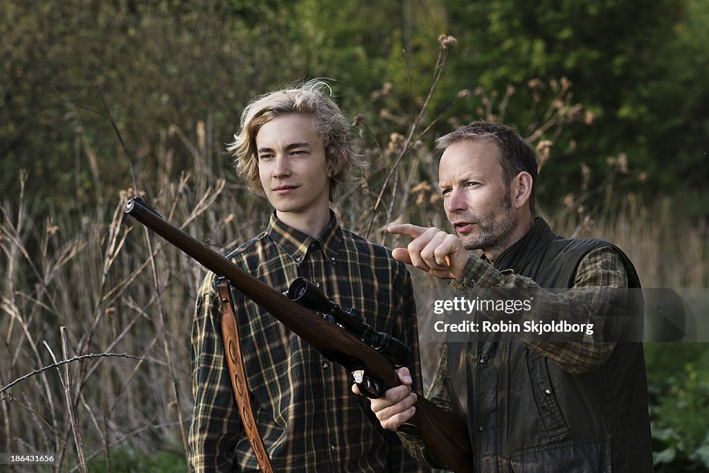 Father and son in nature with rifle
