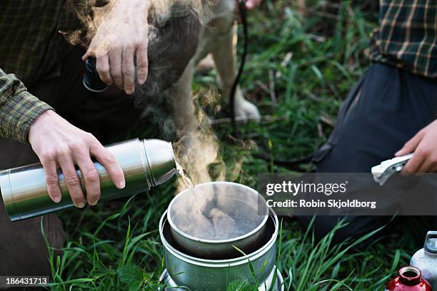 closeup of hand with thermos and primus device - insulated drink container stock pictures, royalty-free photos & images