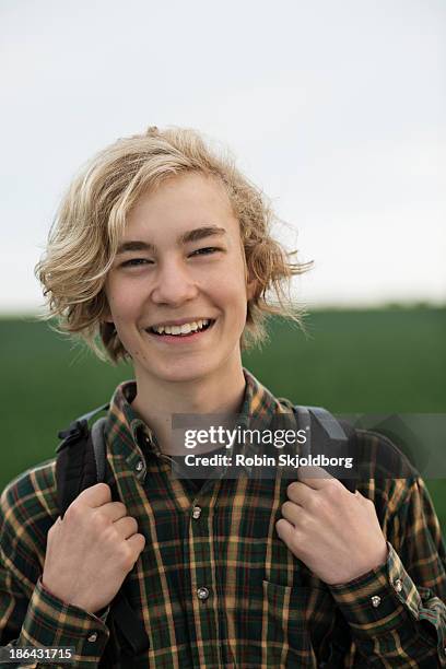 young man with with rucksack smiling - one teenage boy only fotografías e imágenes de stock