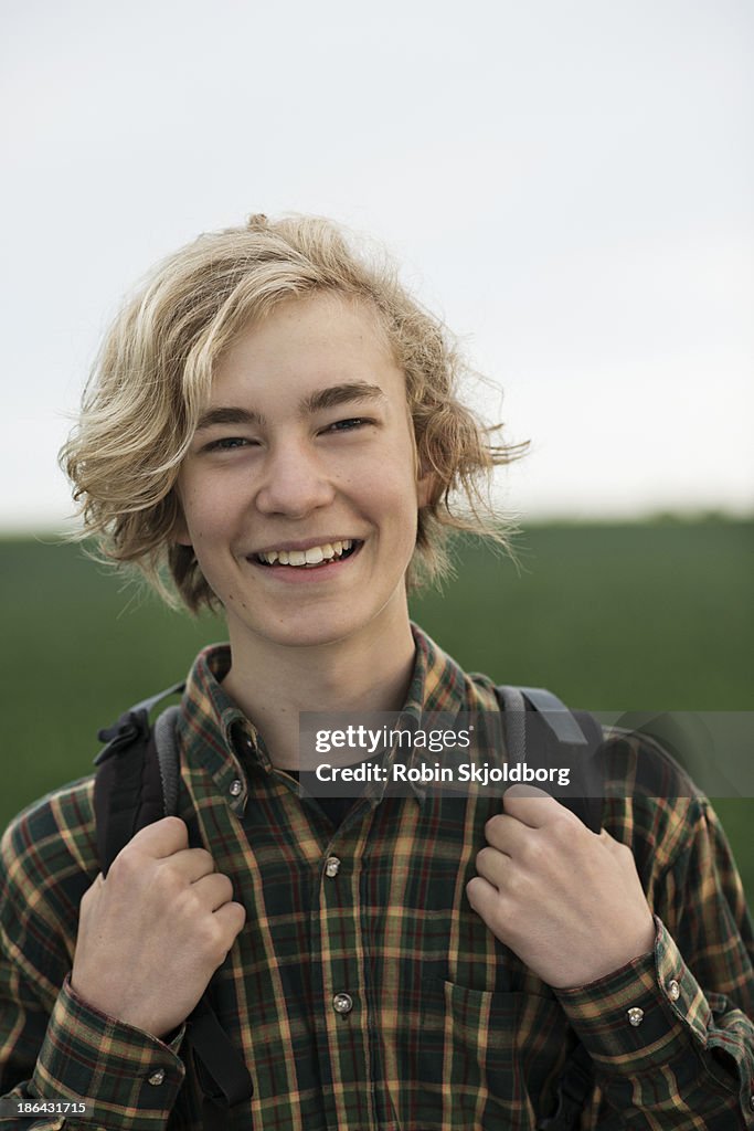 Young man with with rucksack smiling