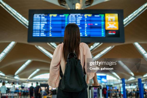 businesswoman standing in airport - commercial airplane stock pictures, royalty-free photos & images