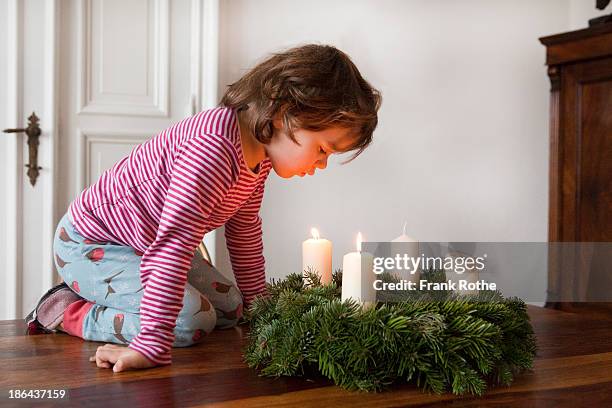 child blowing out advent candle - kids advent stock pictures, royalty-free photos & images