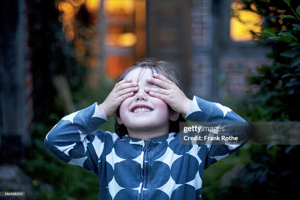 Child covers the eyes with both hands