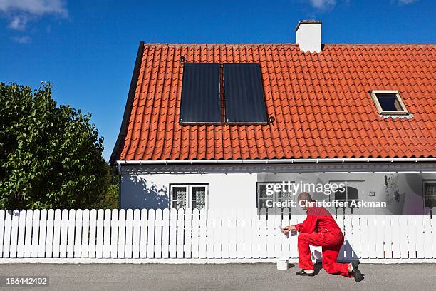 elderly man painting fence - painted roof stock pictures, royalty-free photos & images