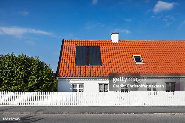 house with solar heating panels - roof tile stock pictures, royalty-free photos & images