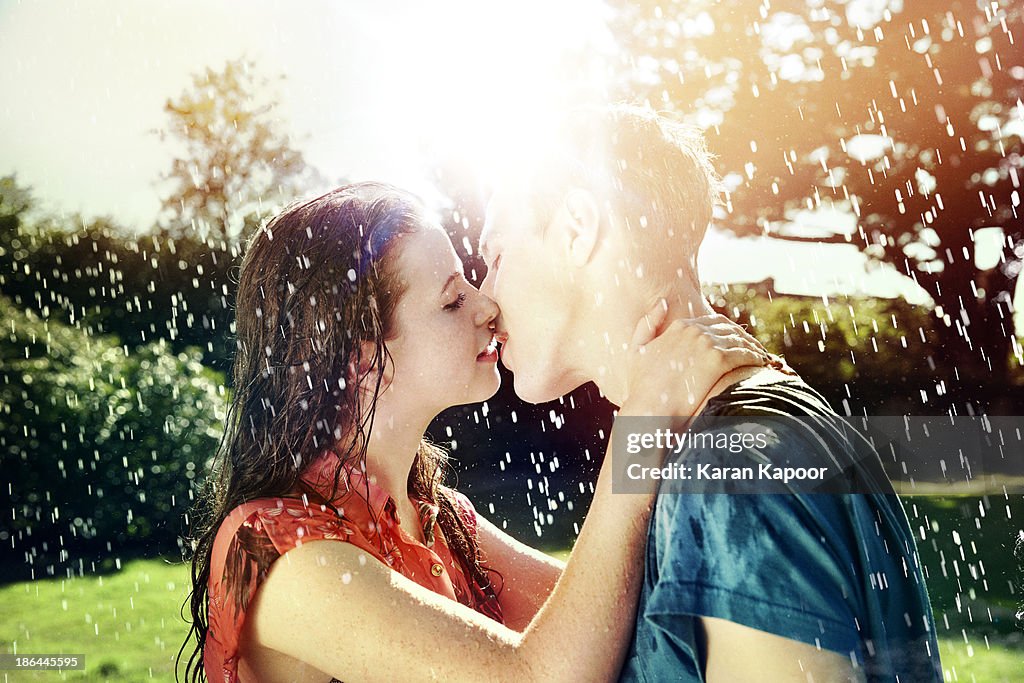 Teenage couple kissing in rain