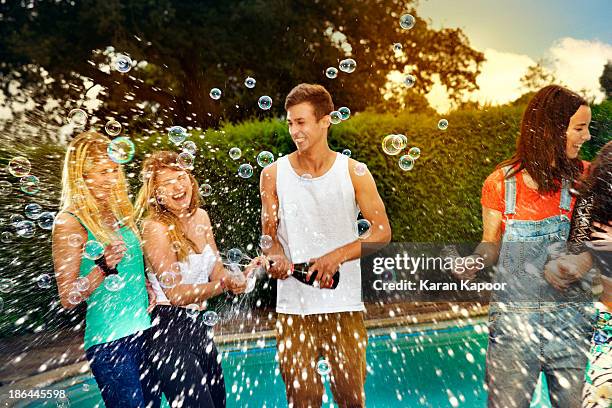 teenager spraying girls with champagne - spraying champagne stock pictures, royalty-free photos & images