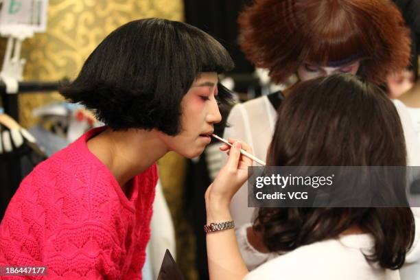 Model prepares backstage ahead of the BROADCAST Wang Tao Collection show during Mercedes-Benz China Fashion Week Spring/Summer 2014 at Beijing Hotel...