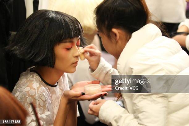 Model prepares backstage ahead of the BROADCAST Wang Tao Collection show during Mercedes-Benz China Fashion Week Spring/Summer 2014 at Beijing Hotel...