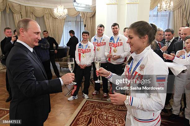 Russian President Vladimir Putin toasts an athlete at a meeting with the winners of the 2013 World Combat Games October 31, 2013 in Moscow, Russia....