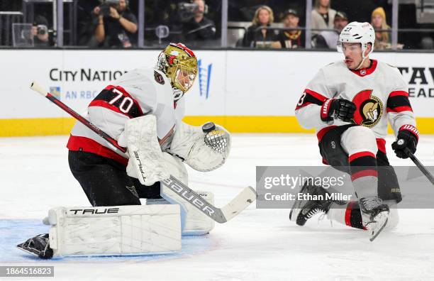 Joonas Korpisalo of the Ottawa Senators makes a save against the Vegas Golden Knights as Travis Hamonic of the Senators looks on in the second period...