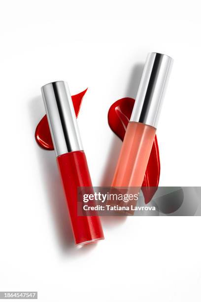 rich red lip glosses on lipstick smears isolated on white colored background. beauty industry and cosmetics with copy space for text, design elements, logo. makeup and skin care products. - schminkpalette kosmetikartikel stock-fotos und bilder
