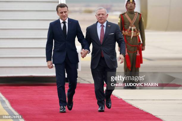Jordan's King Abdullah II welcomes France's President Emmanuel Macron upon his arrival at Aqaba airport on December 21 during a two-day visit to...