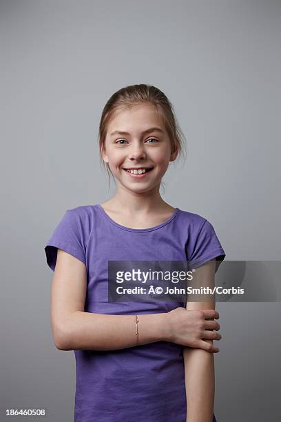 studio shot portrait of girl (10-12) in purple t-shirt - mädchen 10 12 stock-fotos und bilder