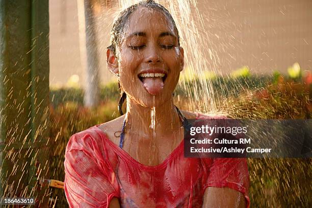 woman showering with tongue sticking out - women in wet tee shirts stock pictures, royalty-free photos & images